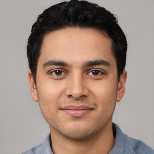 Joyful latino young-adult male with short  black hair and brown eyes