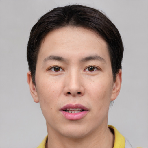 Joyful asian young-adult male with short  brown hair and brown eyes