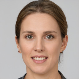 Joyful white young-adult female with medium  brown hair and grey eyes