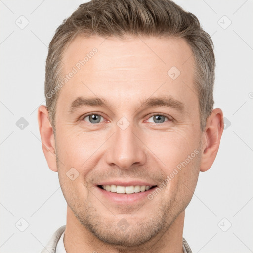 Joyful white young-adult male with short  brown hair and grey eyes