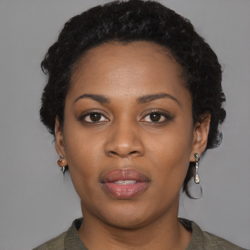 Joyful black young-adult female with short  black hair and brown eyes