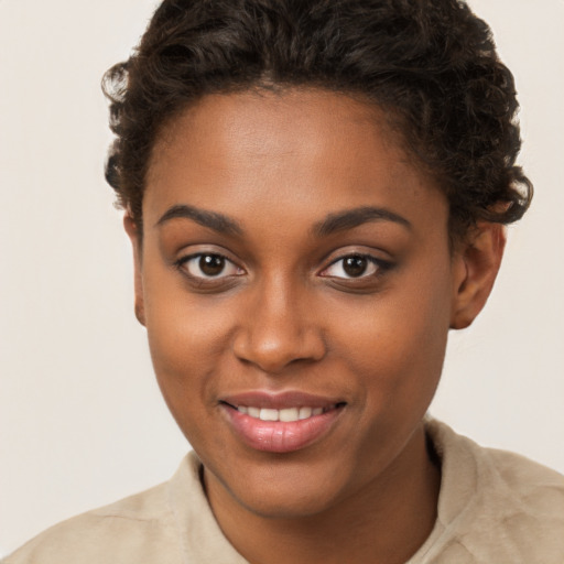 Joyful black young-adult female with short  brown hair and brown eyes