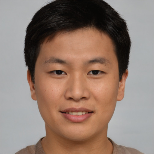 Joyful asian young-adult male with short  brown hair and brown eyes
