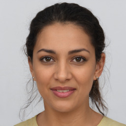 Joyful latino young-adult female with medium  brown hair and brown eyes