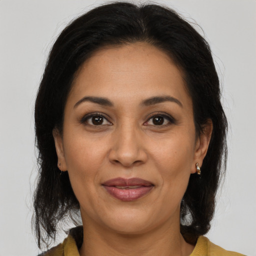 Joyful latino adult female with medium  brown hair and brown eyes