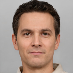 Joyful white young-adult male with short  brown hair and grey eyes