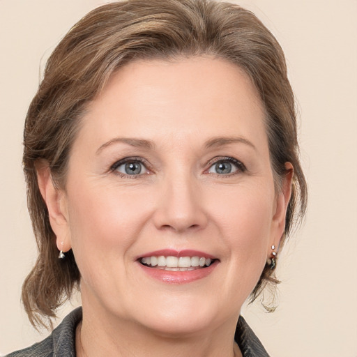 Joyful white adult female with medium  brown hair and grey eyes