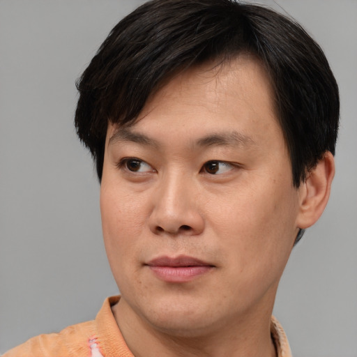 Joyful asian young-adult male with short  brown hair and brown eyes