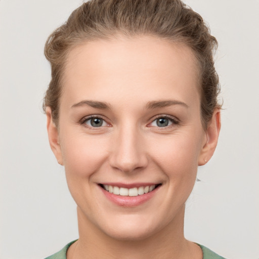 Joyful white young-adult female with short  brown hair and grey eyes