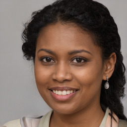 Joyful black young-adult female with long  brown hair and brown eyes