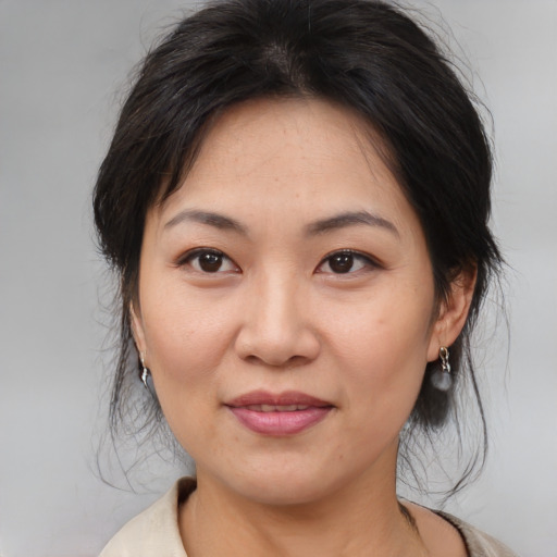 Joyful asian adult female with medium  brown hair and brown eyes