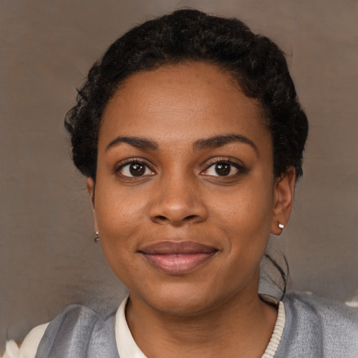 Joyful black young-adult female with short  black hair and brown eyes