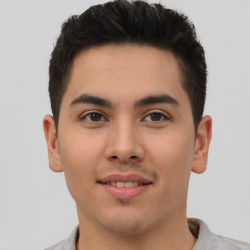 Joyful latino young-adult male with short  brown hair and brown eyes