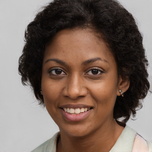 Joyful black young-adult female with long  brown hair and brown eyes