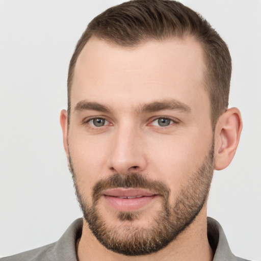 Joyful white young-adult male with short  brown hair and grey eyes