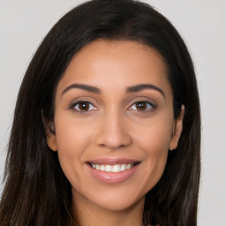 Joyful latino young-adult female with long  brown hair and brown eyes