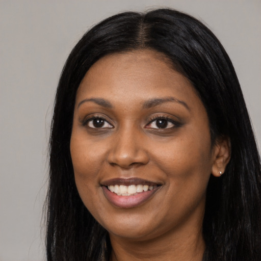 Joyful black young-adult female with long  black hair and brown eyes