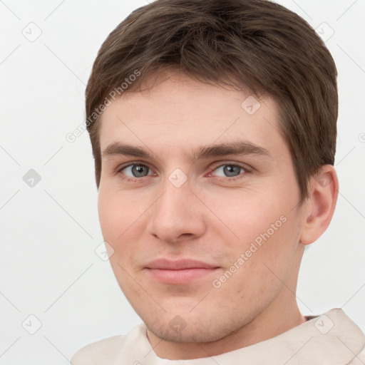 Joyful white young-adult male with short  brown hair and grey eyes