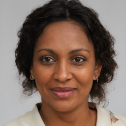 Joyful black adult female with medium  brown hair and brown eyes