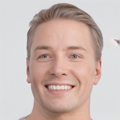 Joyful white young-adult male with short  brown hair and grey eyes