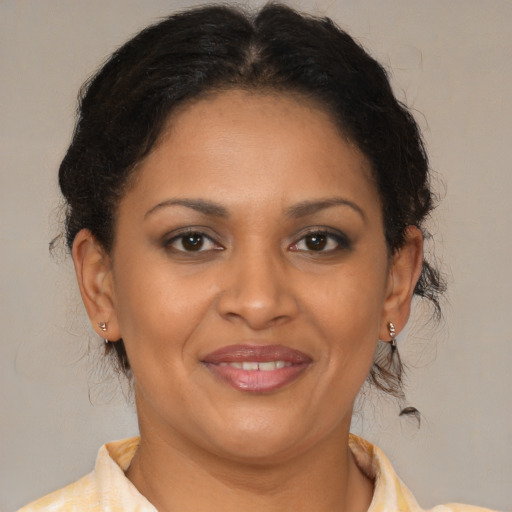 Joyful latino adult female with medium  brown hair and brown eyes