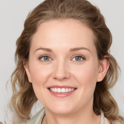 Joyful white young-adult female with medium  brown hair and green eyes