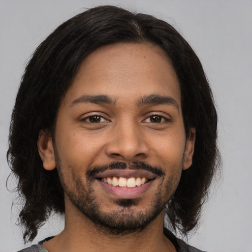 Joyful latino young-adult male with medium  brown hair and brown eyes