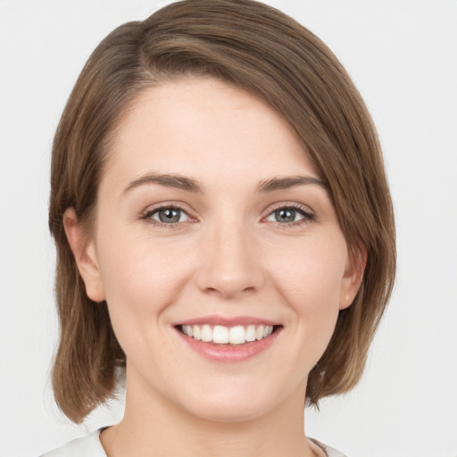 Joyful white young-adult female with medium  brown hair and green eyes