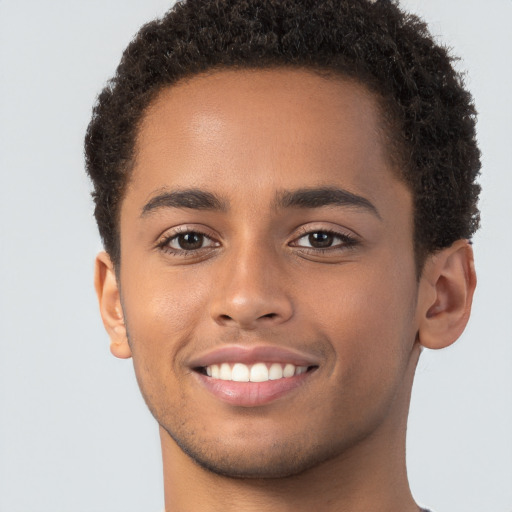 Joyful black young-adult male with short  brown hair and brown eyes