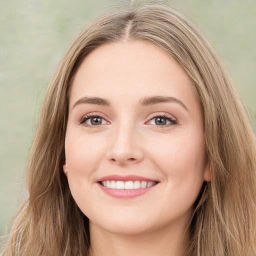 Joyful white young-adult female with long  brown hair and green eyes