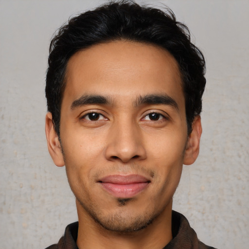 Joyful latino young-adult male with short  black hair and brown eyes