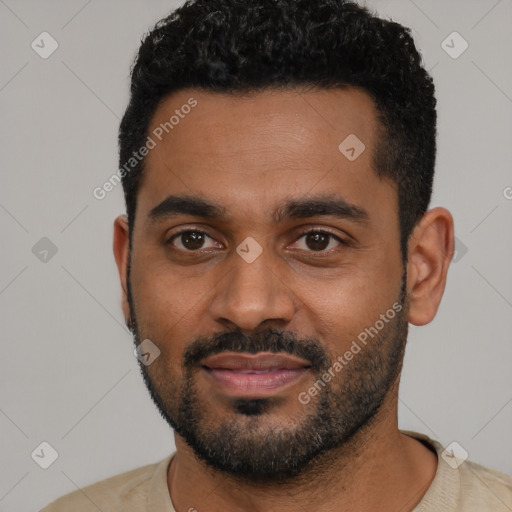 Joyful black young-adult male with short  black hair and brown eyes