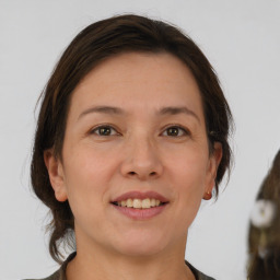 Joyful white adult female with medium  brown hair and brown eyes