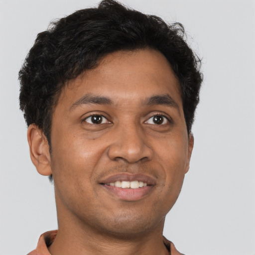Joyful black young-adult male with short  brown hair and brown eyes
