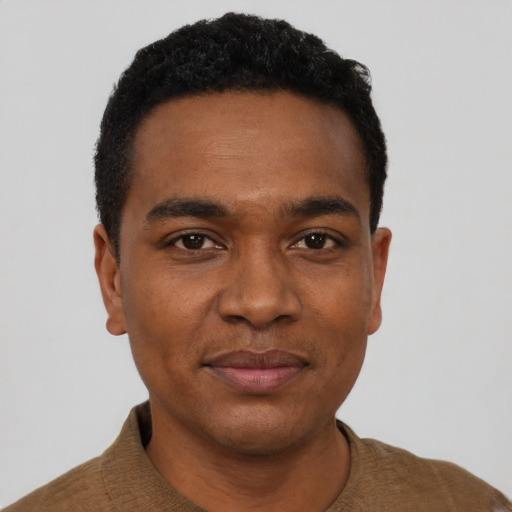Joyful black young-adult male with short  black hair and brown eyes