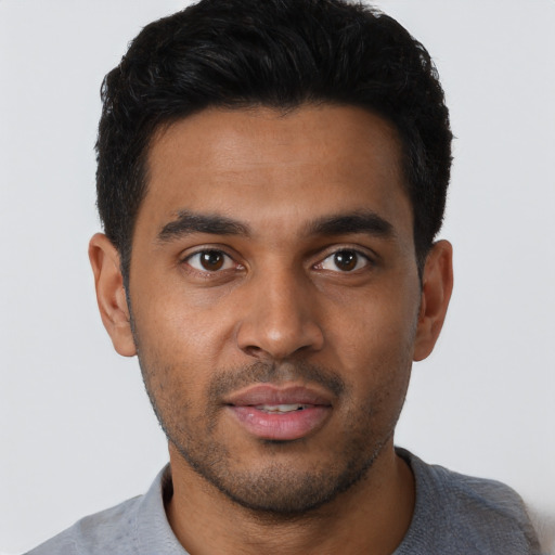 Joyful latino young-adult male with short  brown hair and brown eyes