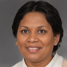 Joyful black adult female with medium  brown hair and brown eyes