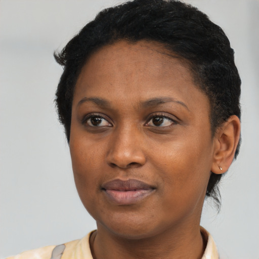 Joyful black young-adult female with short  black hair and brown eyes