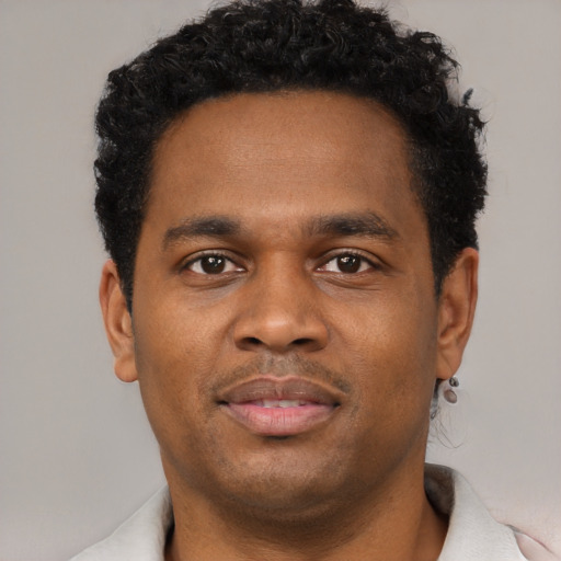 Joyful black young-adult male with short  black hair and brown eyes
