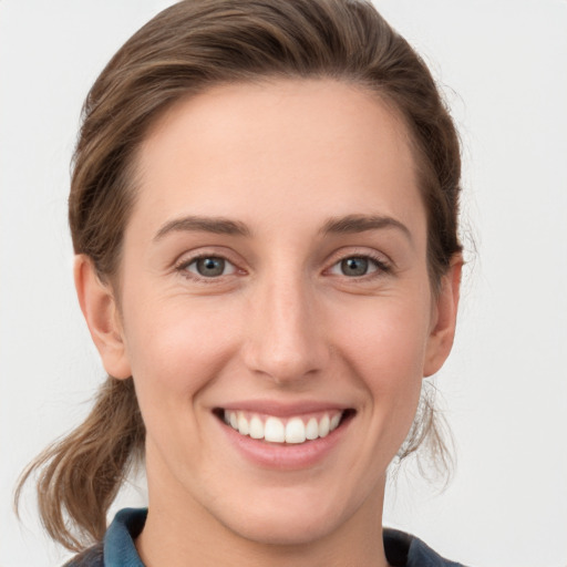 Joyful white young-adult female with medium  brown hair and grey eyes