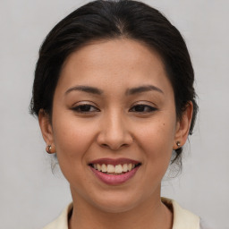 Joyful latino young-adult female with medium  brown hair and brown eyes