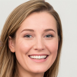 Joyful white young-adult female with long  brown hair and blue eyes