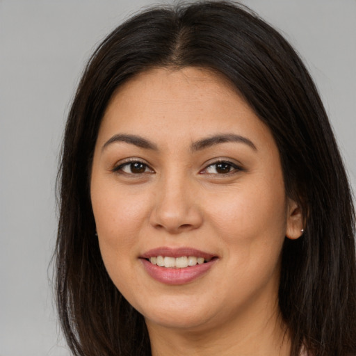 Joyful latino young-adult female with long  brown hair and brown eyes