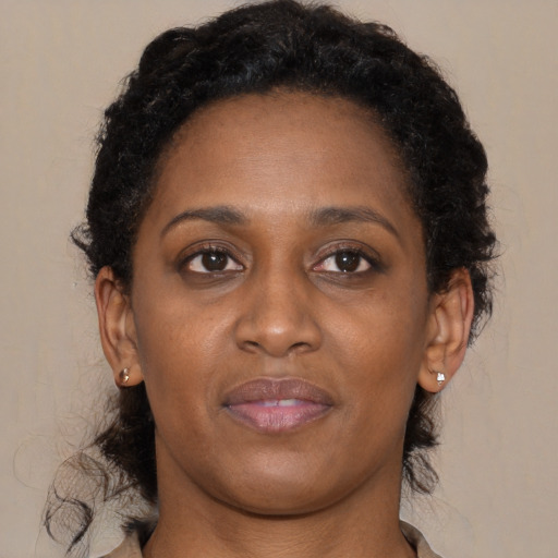 Joyful black adult female with long  brown hair and brown eyes