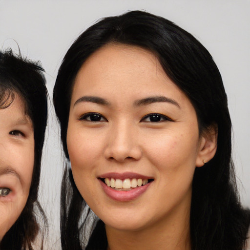 Joyful asian young-adult female with long  black hair and brown eyes