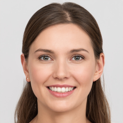 Joyful white young-adult female with long  brown hair and grey eyes