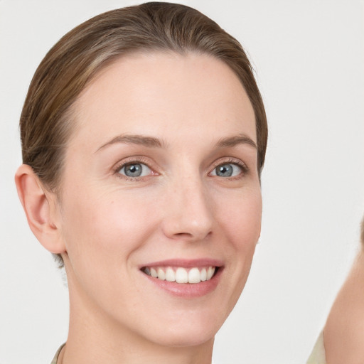 Joyful white young-adult female with short  brown hair and grey eyes