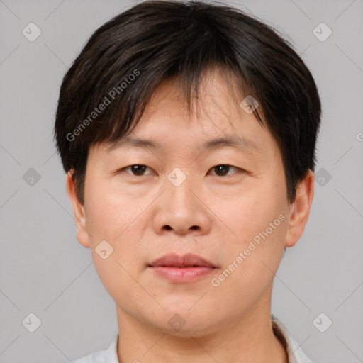 Joyful asian adult male with short  brown hair and brown eyes