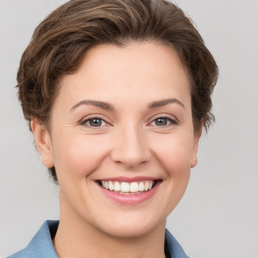 Joyful white young-adult female with short  brown hair and grey eyes