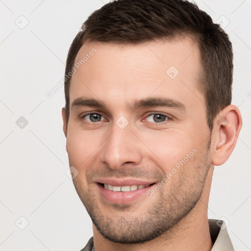 Joyful white young-adult male with short  brown hair and brown eyes